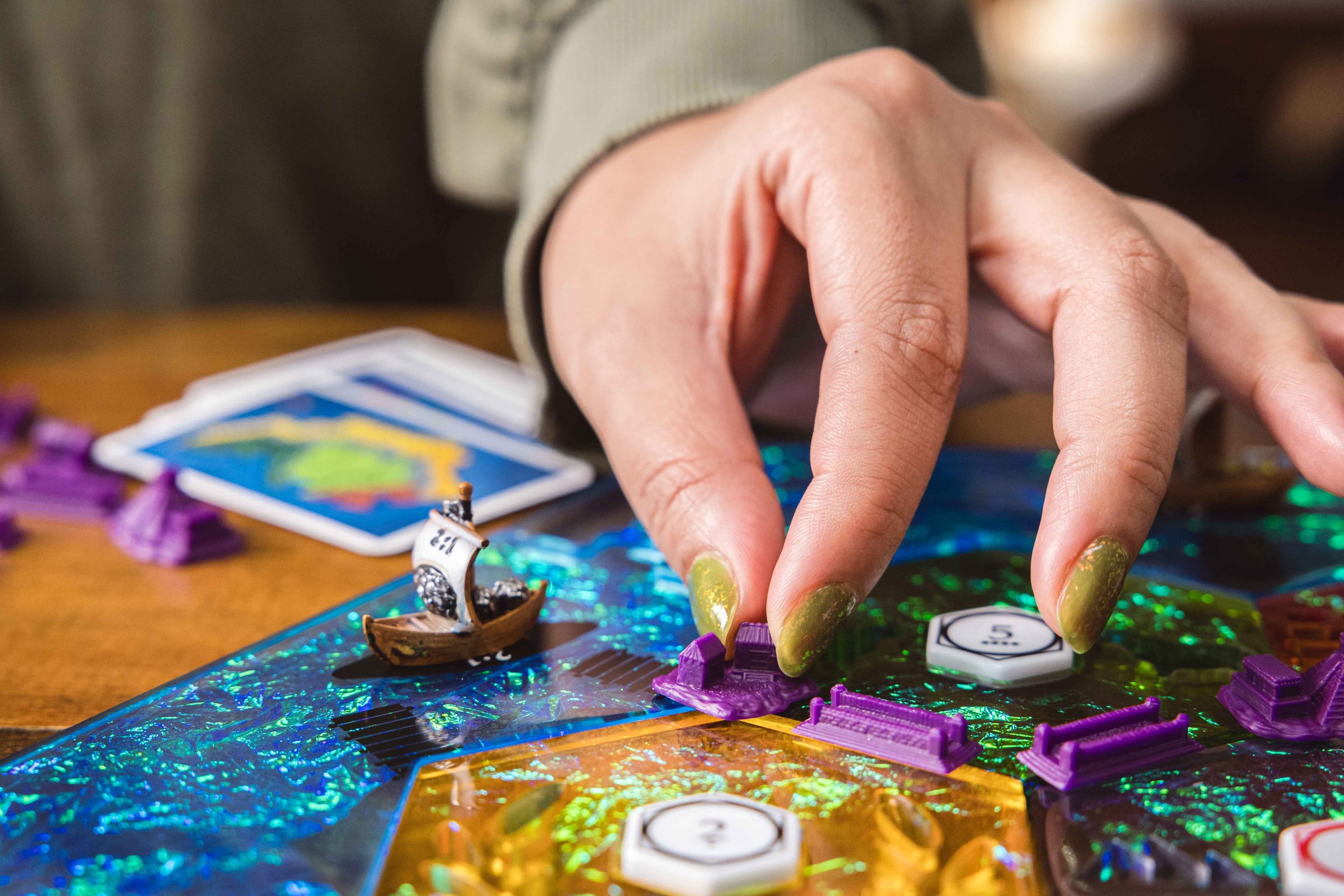 A picture of someone placing a piece in Catan with Fanroll’s new Catan Masterpiece Series pieces.